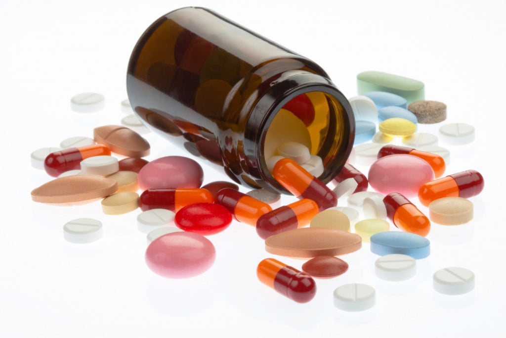 complementary medicines - pills spill out of brown bottle