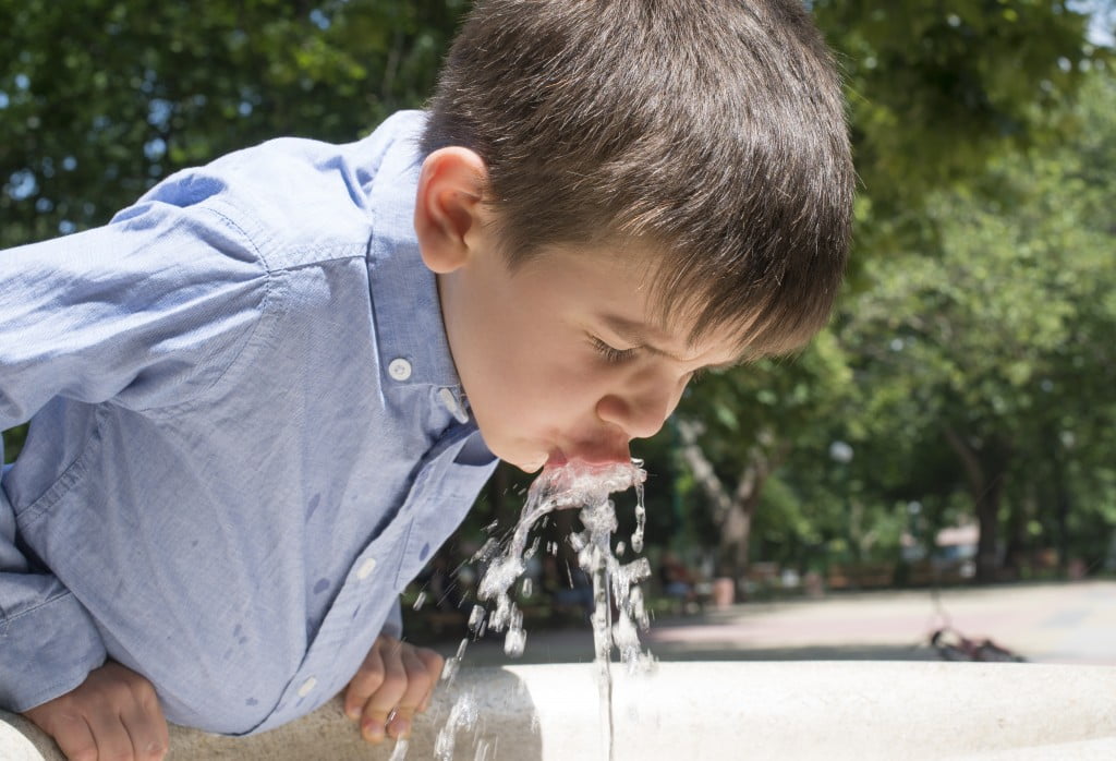 water fluoridation: boy drinking out of bubbler