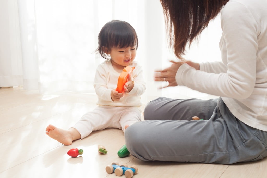 FIP launches MCHN resources: little girl plays with toys next to mother