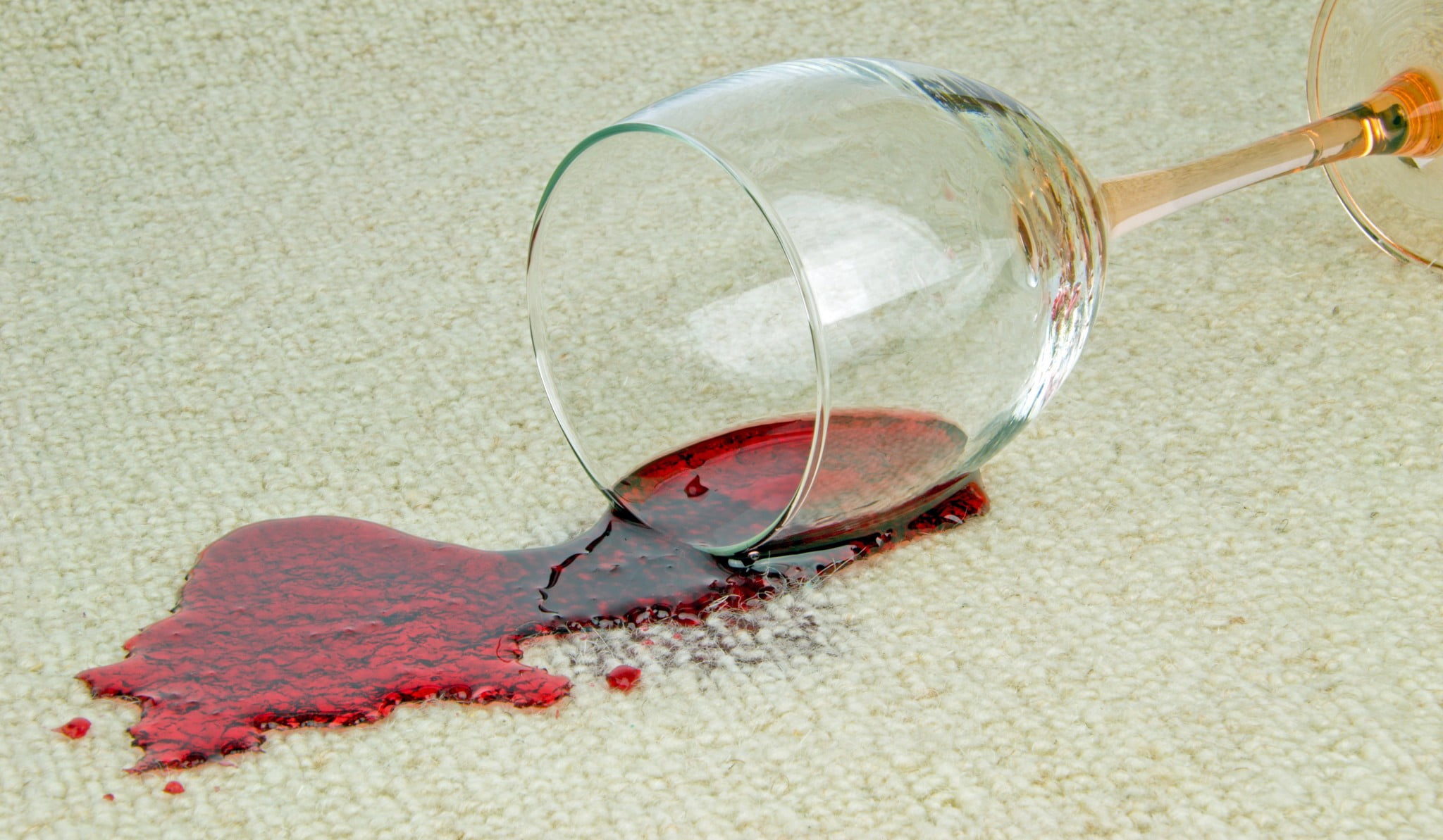 drug treatments: red wine spills from glass onto beige carpet