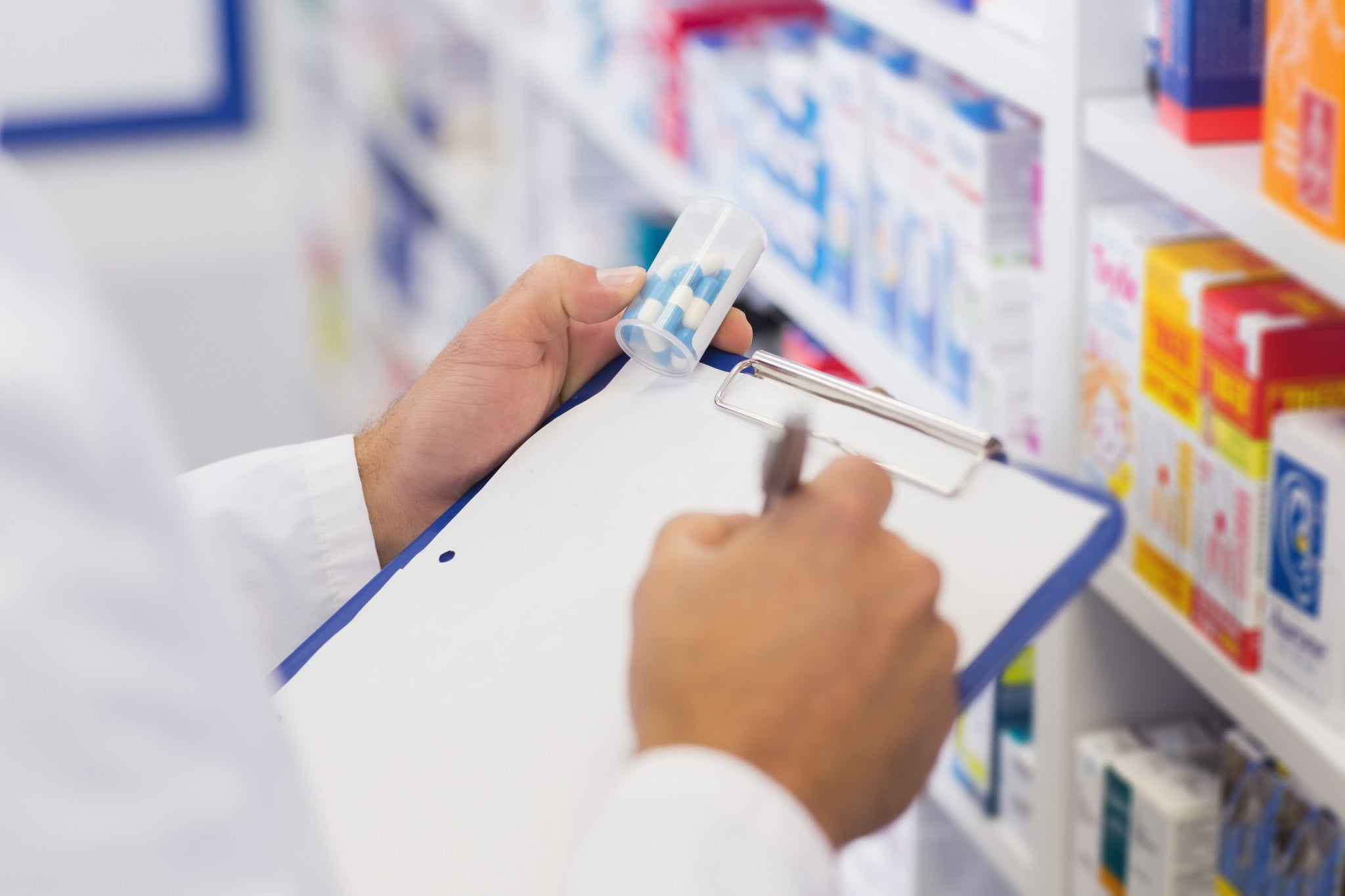 Pharmacist writes on clipboard