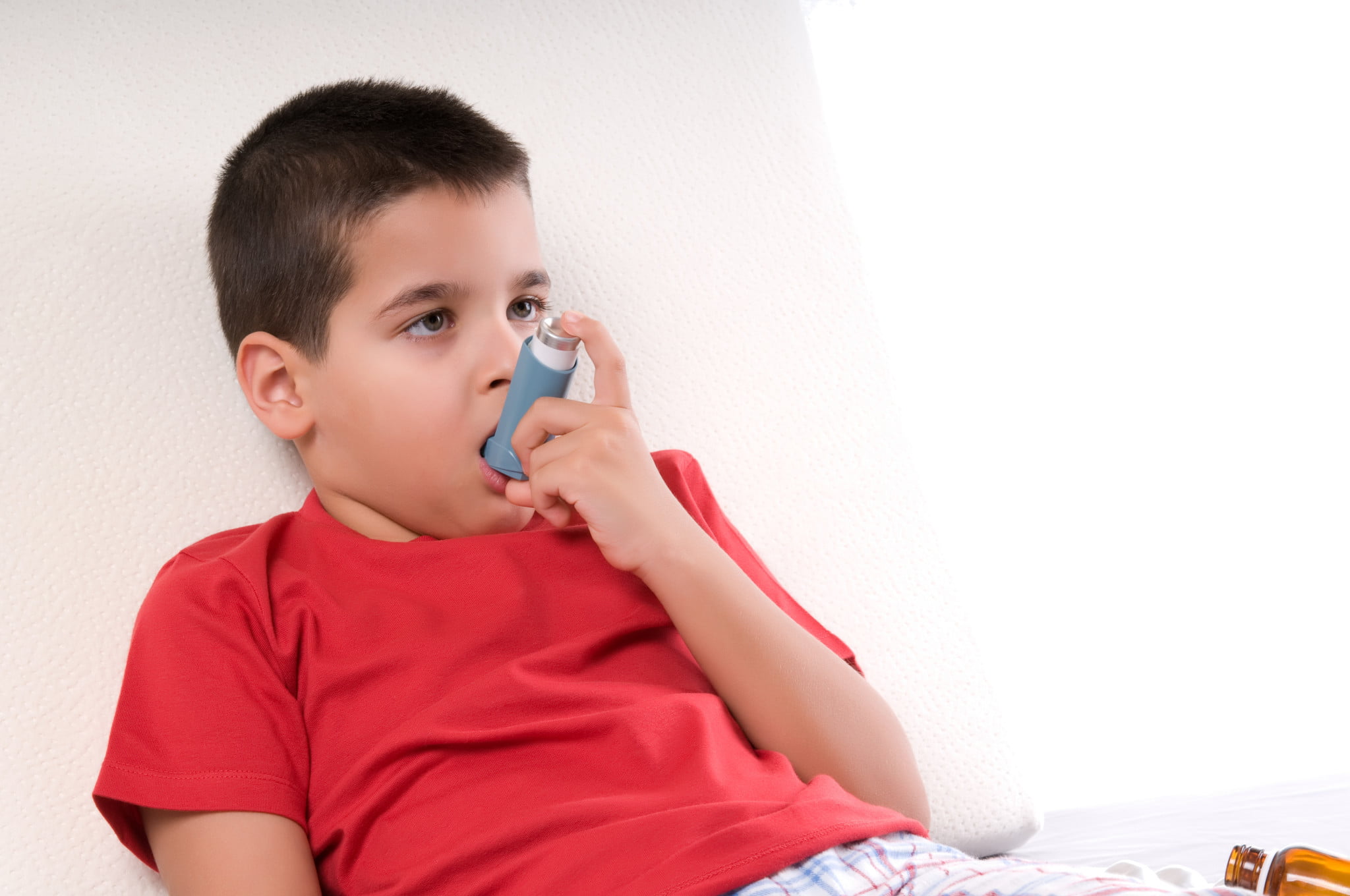 boy wtih asthma uses reliever puffer