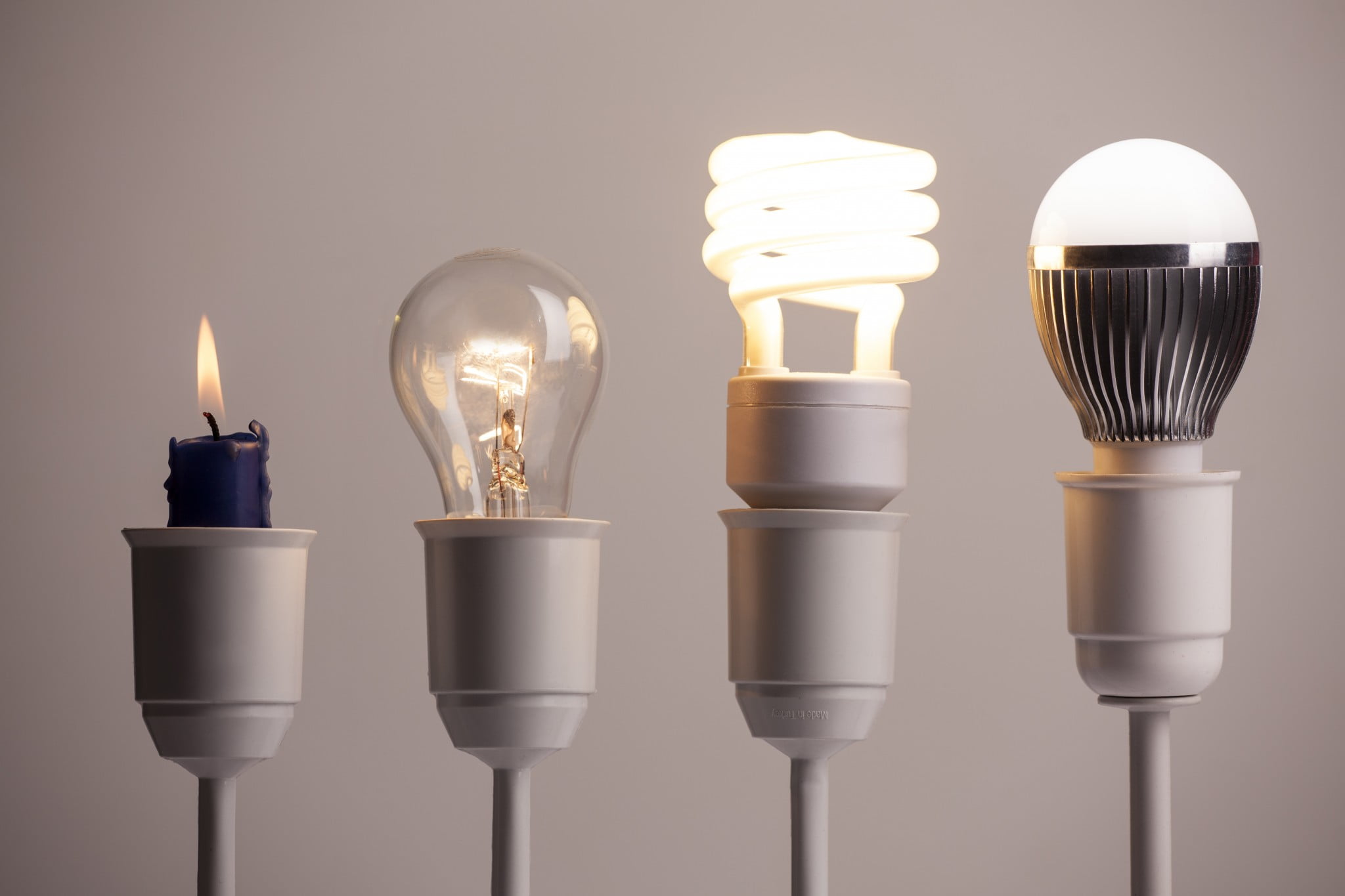 innovation: candle, tungsten bulb, two modern light bulbs