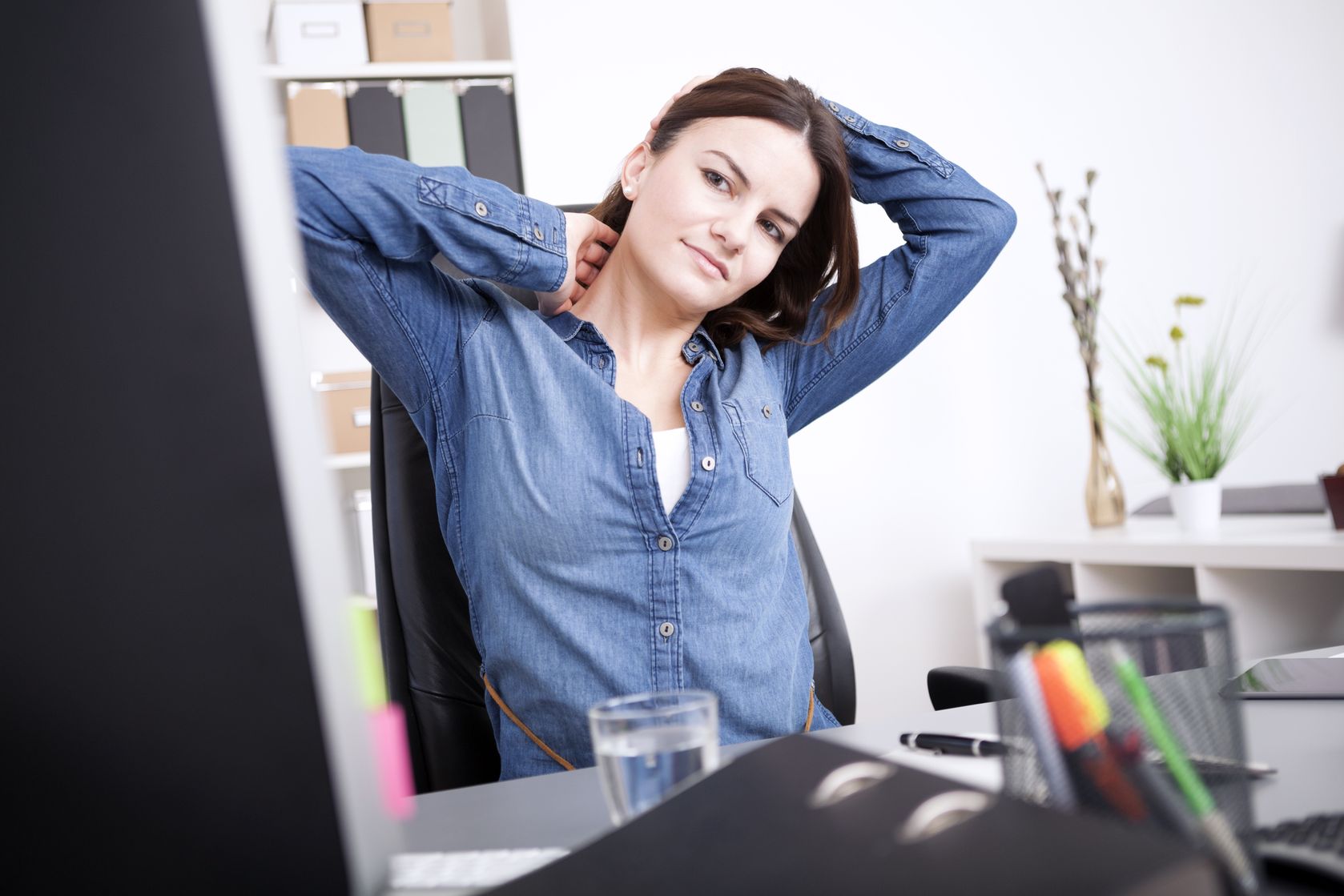 chronic pain: woman with back pain at desk