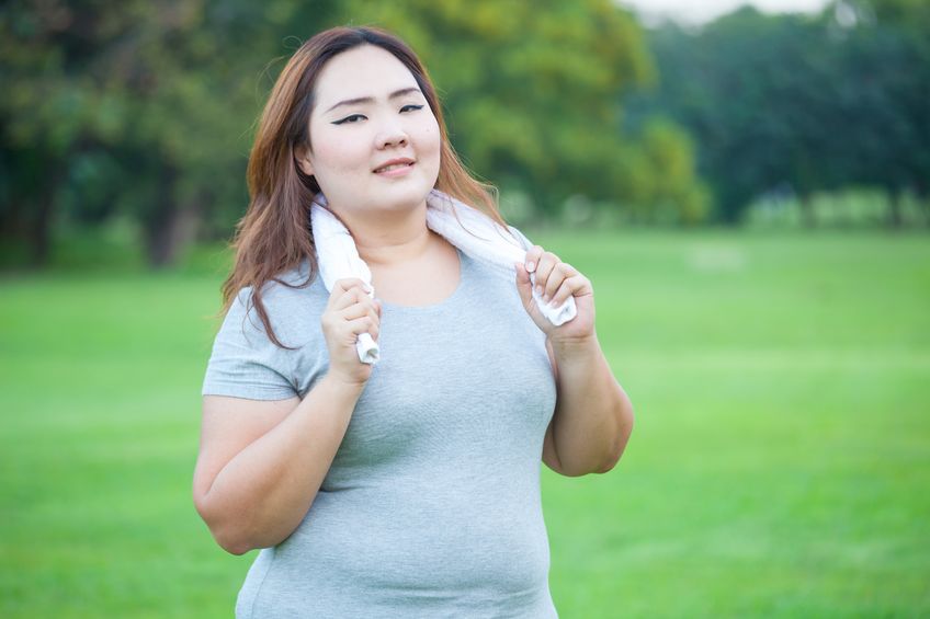 obese woman exercising in the park