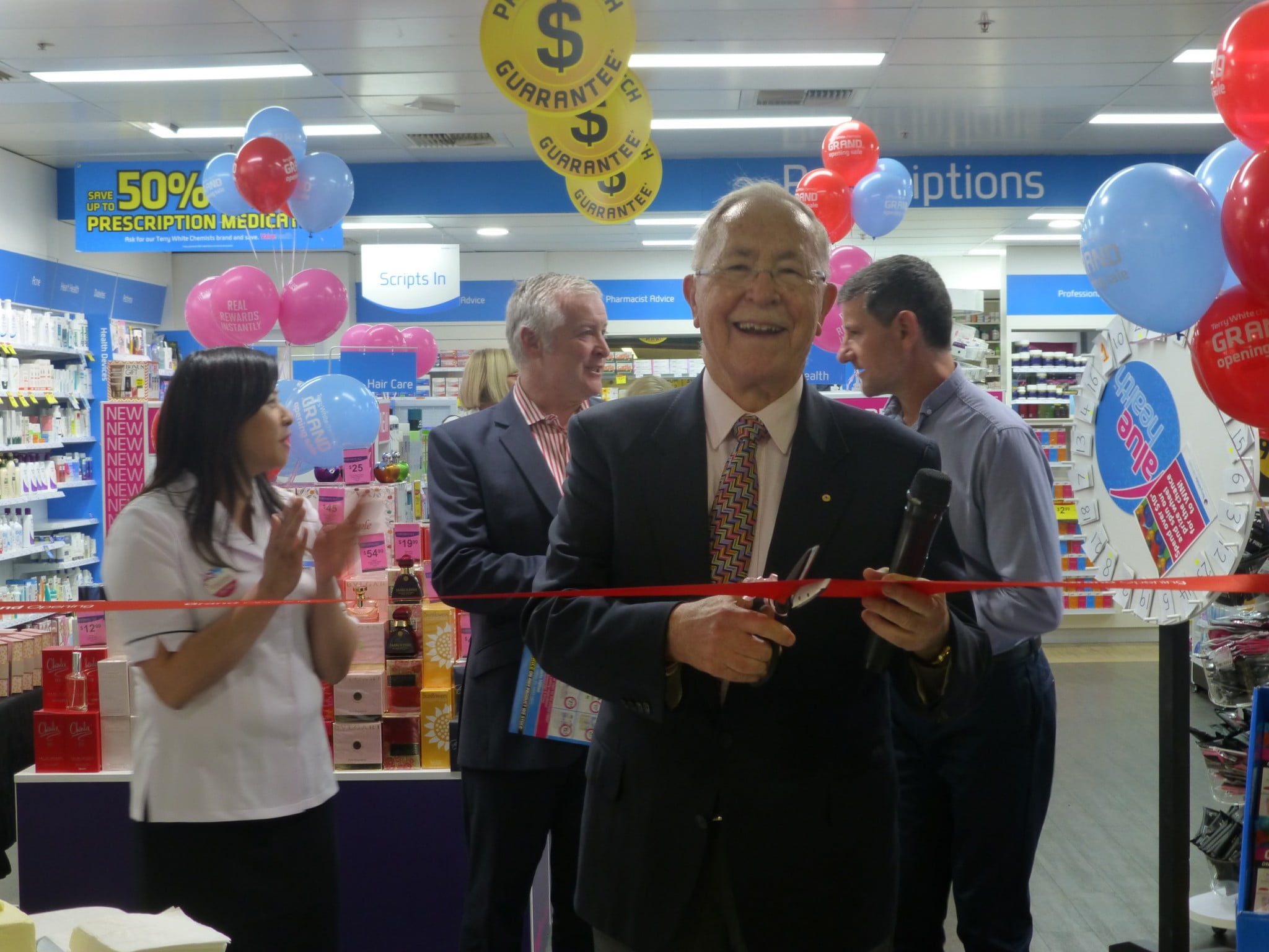 Terry White cuts the ribbon at Terry White Chemists Hilton