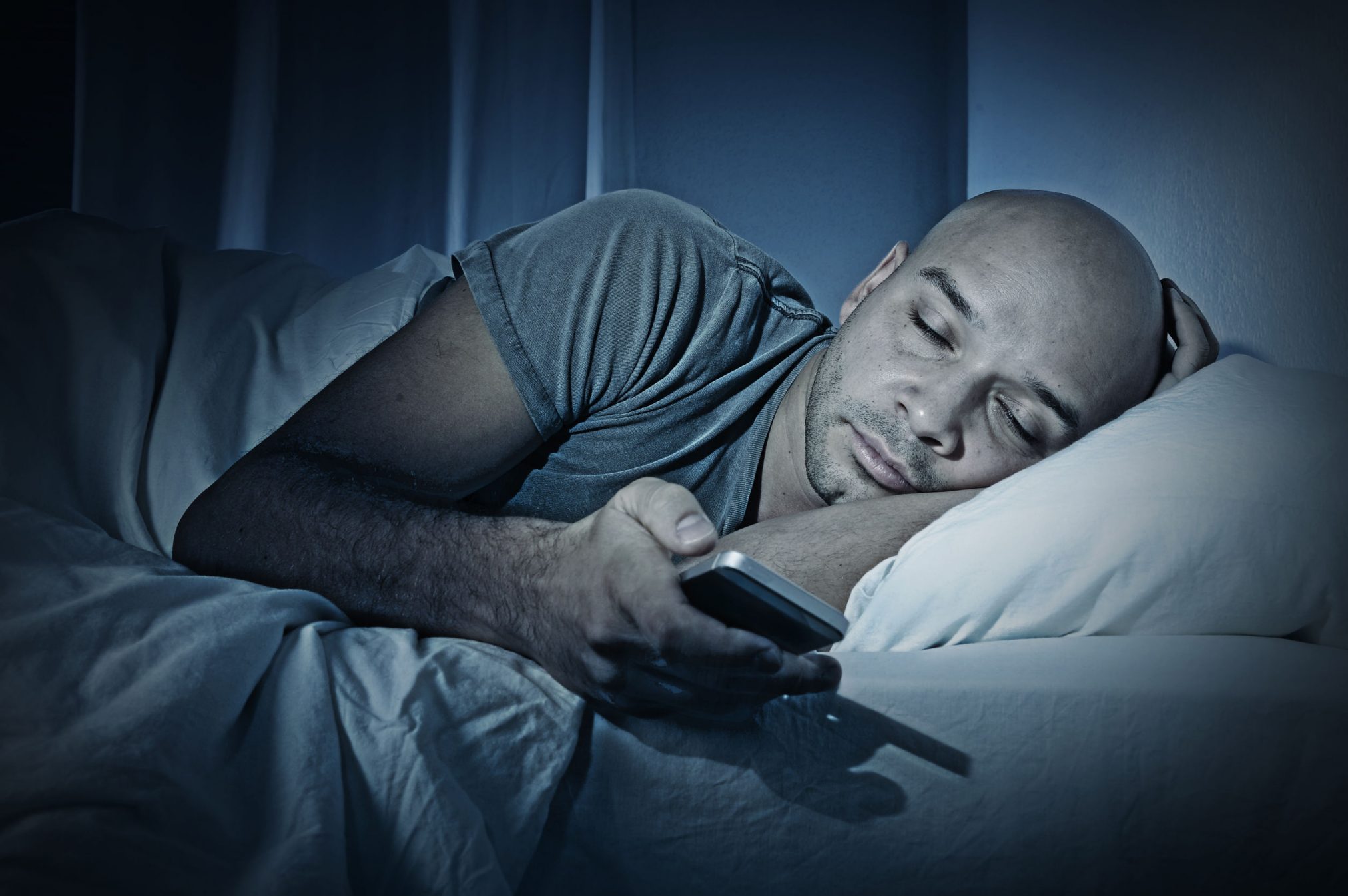 man in bed with smartphone