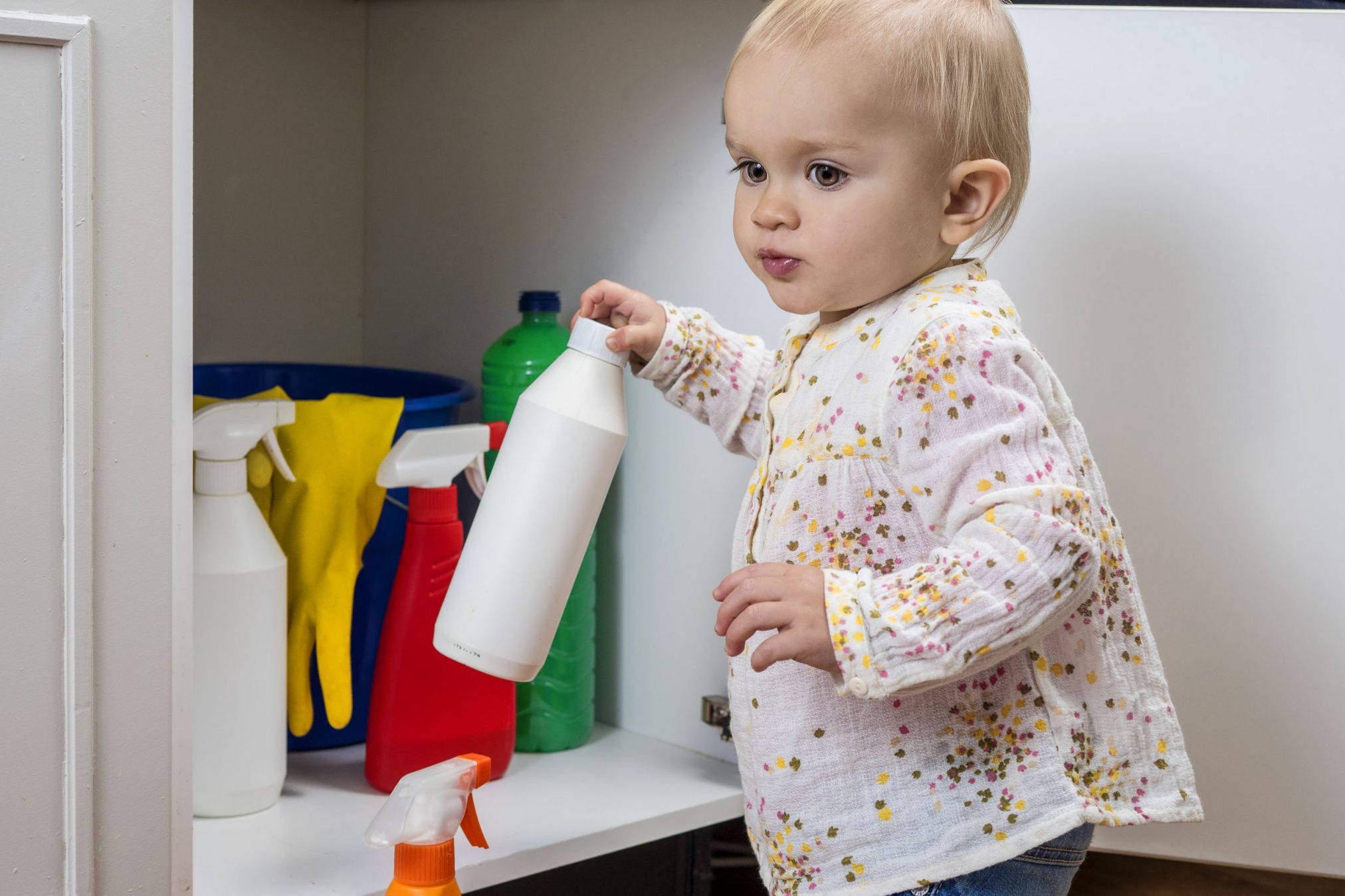 toddler plays with cleaners and flyspray