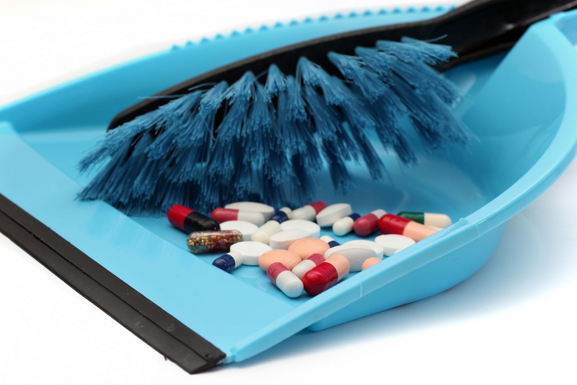 pills in brush and dustpan