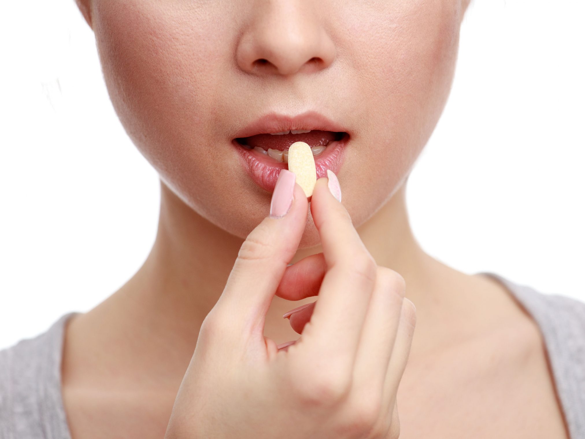 51906249 - woman taking a tablet. close up hand with a pill and the mouth, isolated on white background