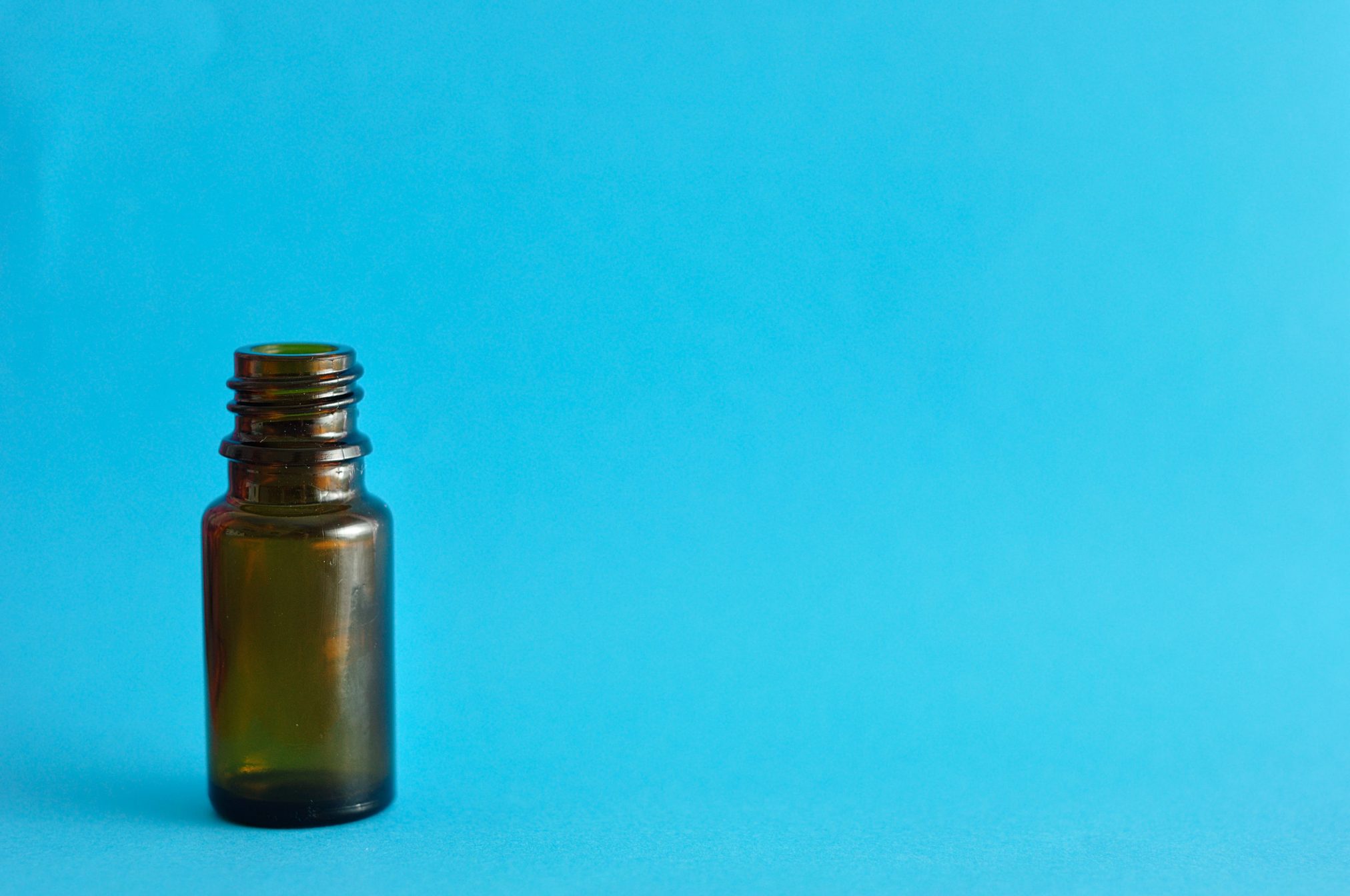 62264298 - a small brown bottle isolated on a blue background