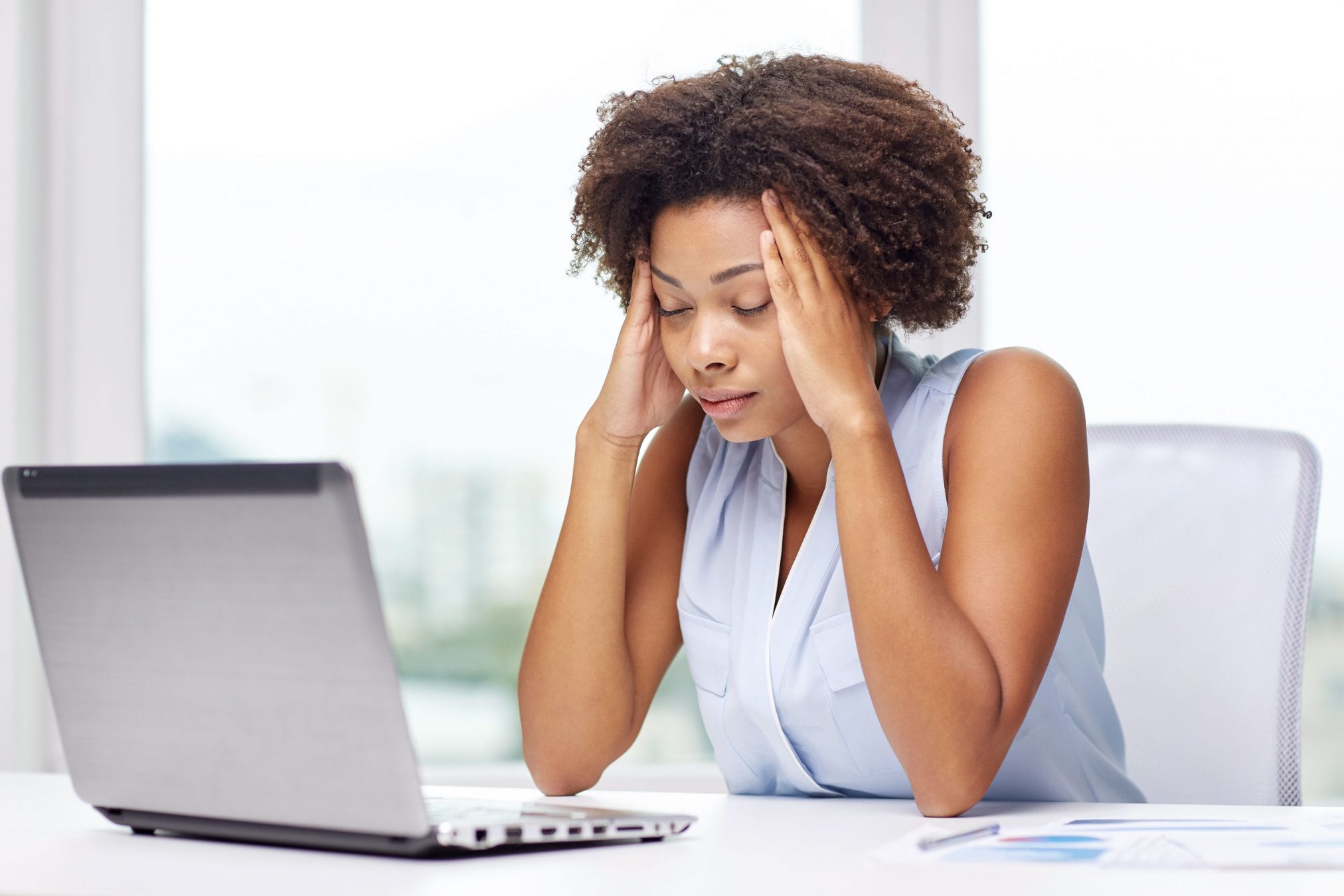 woman at desk with headache
