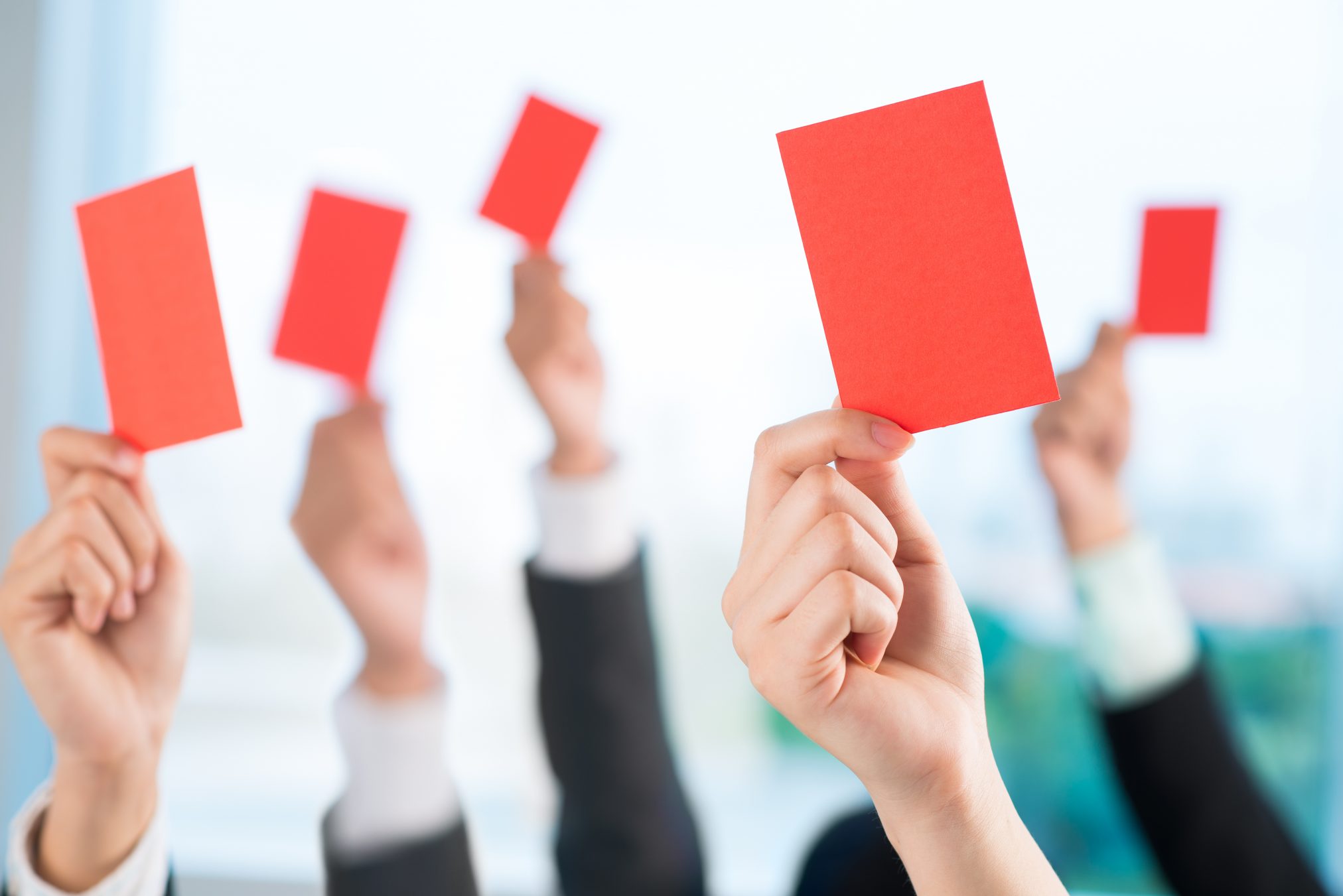 business owners holding up red cards for reprimand