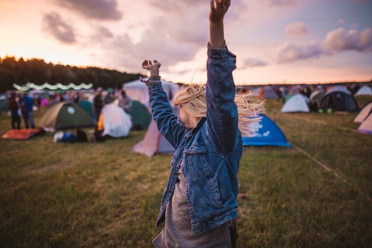 woman dances at music festival at dusk