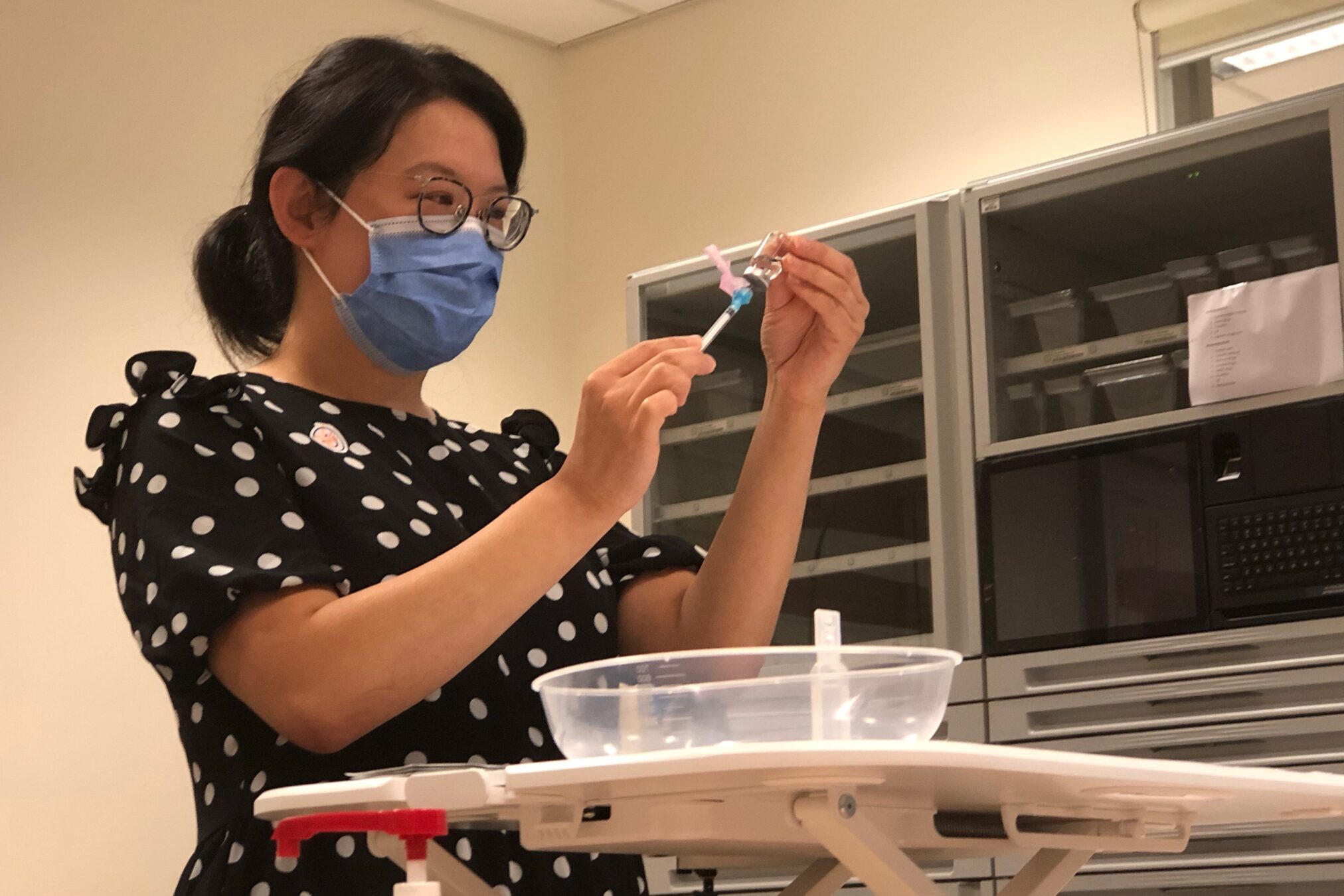 Deputy Director of Pharmacy Erica Tong prepares syringes of the first COVID-19 vaccine