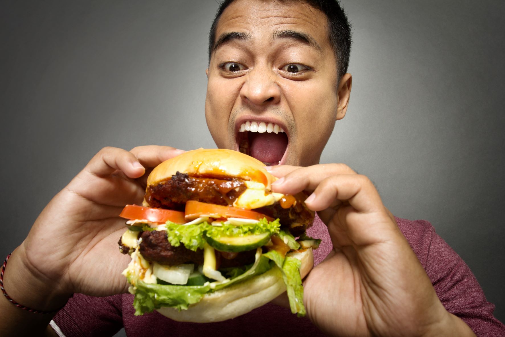man eating sloppy hamburger